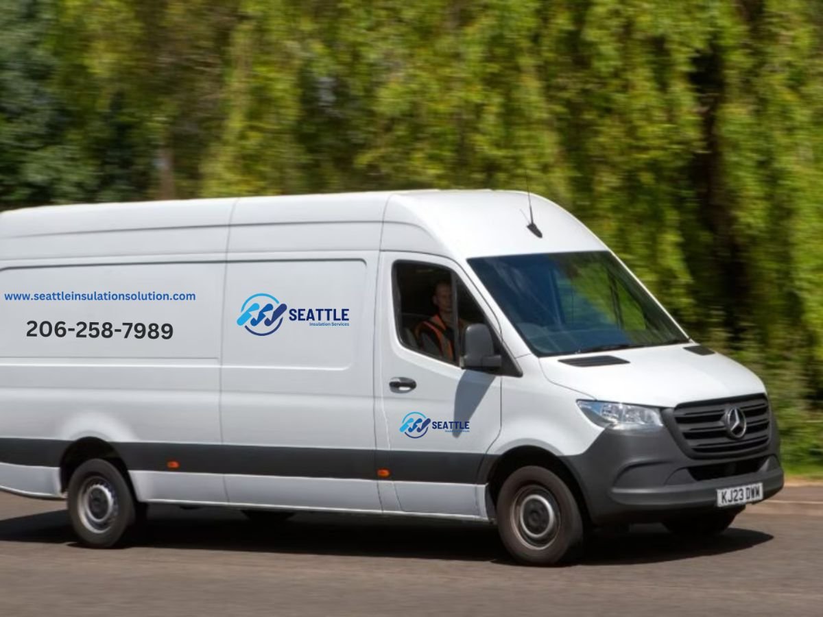 A white van with "Seattle" branding travels down a sunny road, featuring contact details on its side.